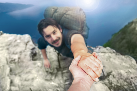 SOLVEA: Im Insolvenzfall gemeinsam anpacken, wenn es schwierig wird Bergsteiger ergreift Hand, die ihn nach oben zieht